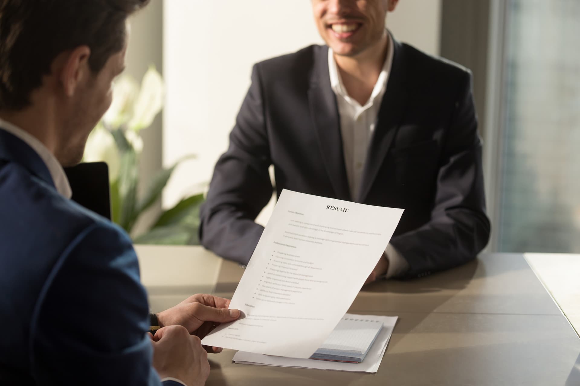 Hiring manager reviewing a service member’s resume during an in-person interview, symbolizing the transition from military to civilian employment.